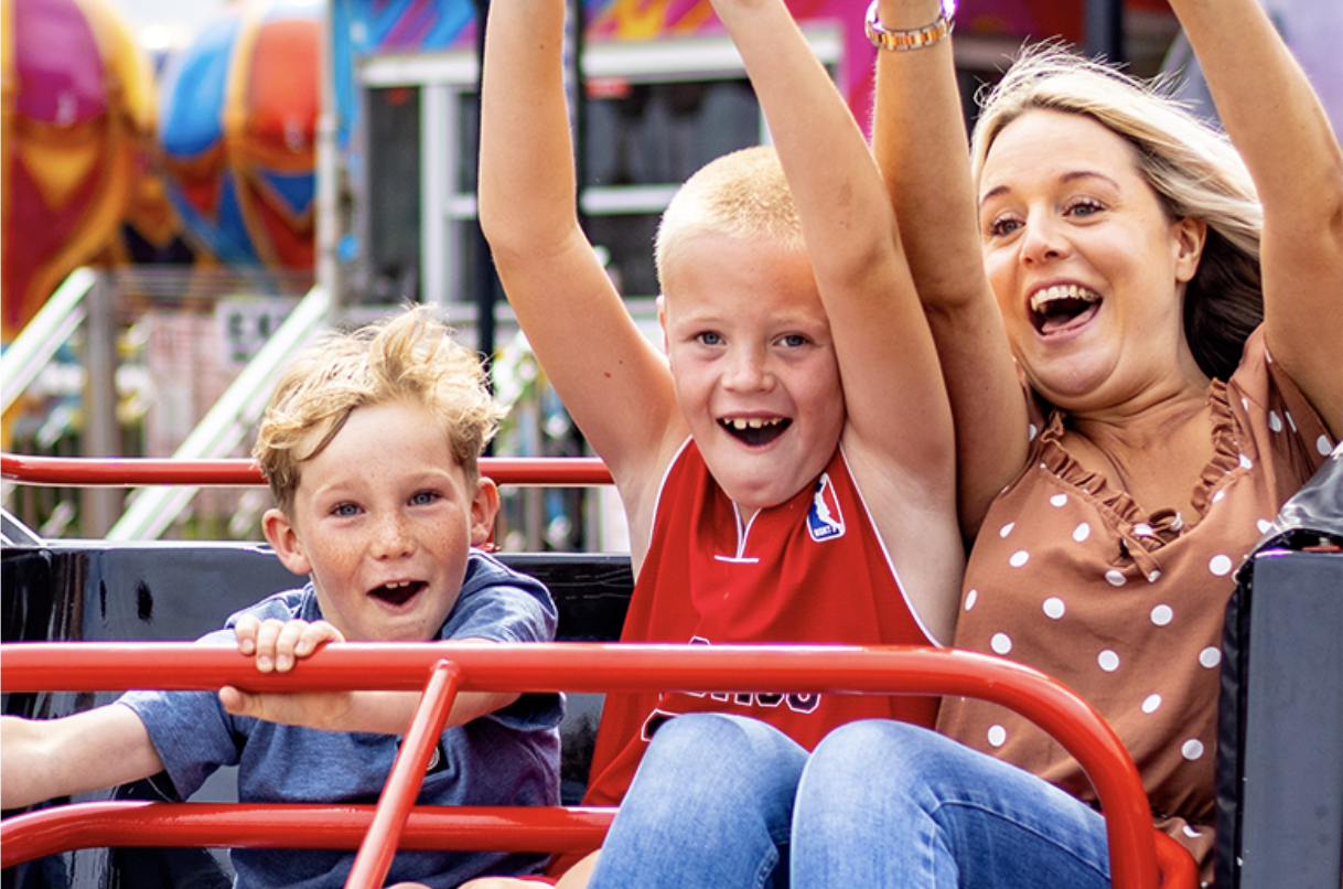 Woman and two boys enjoying a fairground ride